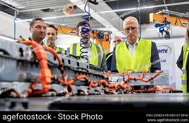 24 August 2023, Hamburg: Peter Tschentscher (SPD, r), First Mayor of Hamburg, informs himself at the company European Metal Recycling (EMR) about the work...
