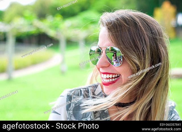 Young happy blonde woman laughing on the lawn