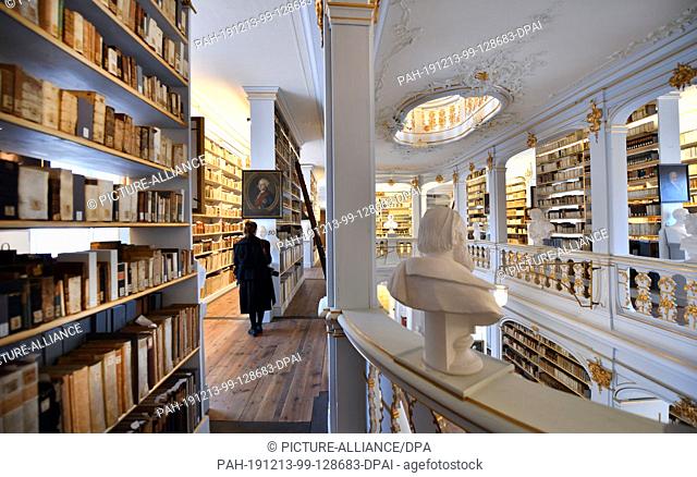 12 December 2019, Thuringia, Weimar: A visitor visits the rococo hall of the Duchess Anna Amalia Library. The Klassik Stiftung Weimar received almost 30