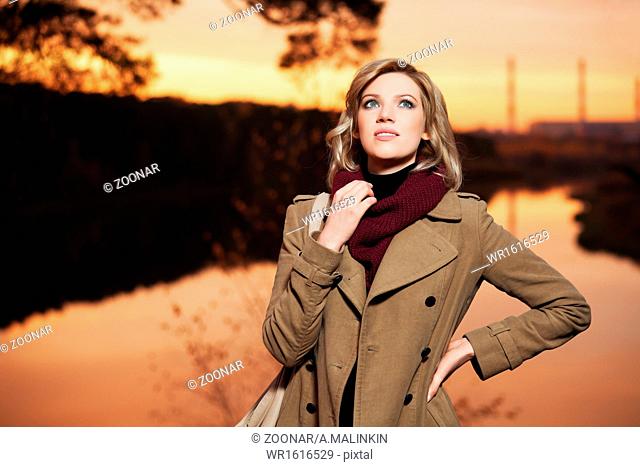 Young blond woman against an autumn nature backgro