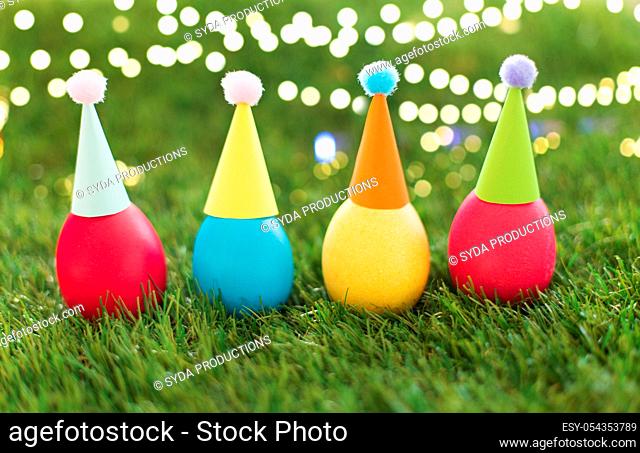 easter eggs in party hats on artificial grass
