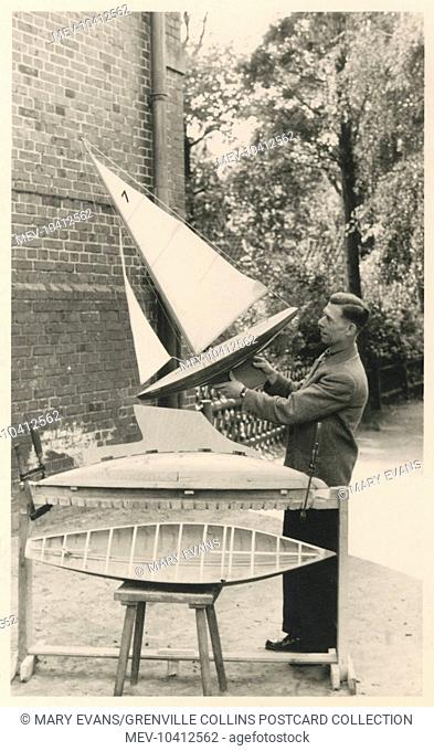 Model boat builder aholding up a finished example of his craft