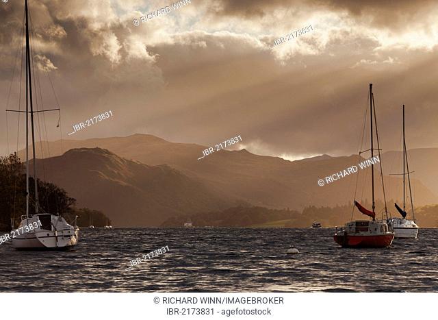 View of Hallin Fell, lit by the autumn sun, with yachts on Ullswater in the foreground, Pooley Bridge, Cumbria, England, United Kingdom, Europe