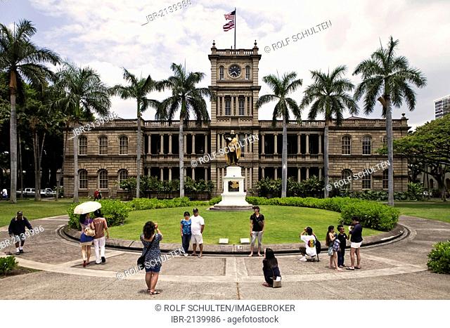 Korean and Japanese tourists taking photographs in front of the statue of first Hawaiian King Kamehameha I, 1758 - 1819, and the building of the Supreme Court