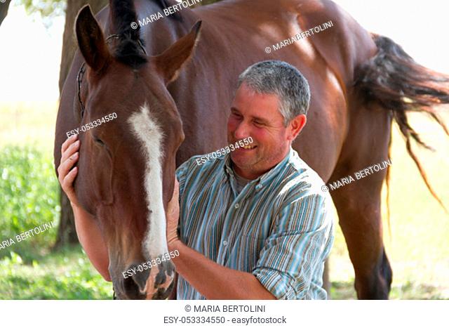 Smiling man with his horse in the Argentine countryside