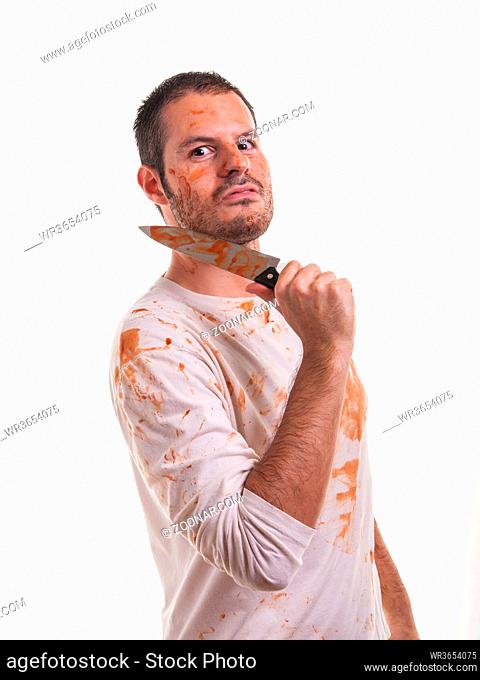 A bloody scene with a man and a blood-covered knife in his hand isolated on white background. Violence and Halloween concept