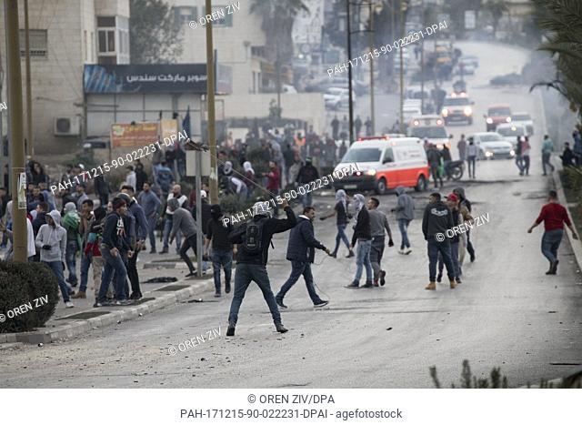 Palestinian protesters use slingshots to hurl stones towards Israeli troops during clashes following a protest against US President Donald Trump's decision to...