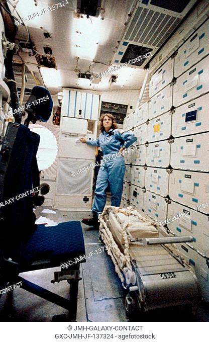 Sharon Christa McAuliffe, a school teacher Concord New Hampshire, surveys a ground training replica of the quarters she'll be using in space when the space...