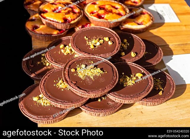 Chocolate and pistachio tarts on display on a market stall in the UK