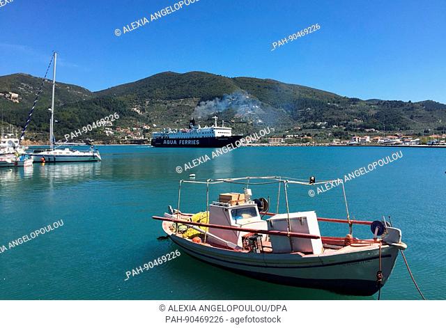 A fishing boat and a ferry near the harbour on the island of Skopelos, Greece, 18 April 2017. Locals are hoping that this summer brings a greater number of...