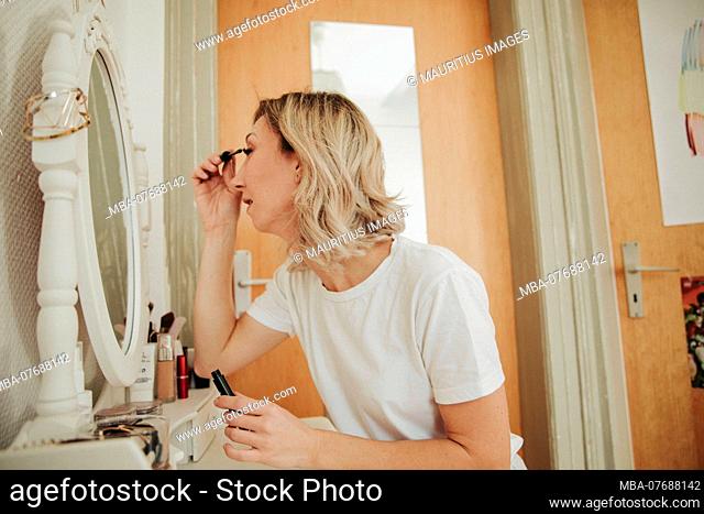 Woman is putting on makeup