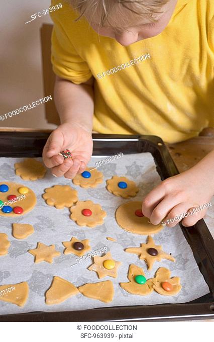 Child decorating biscuits with coloured chocolate beans