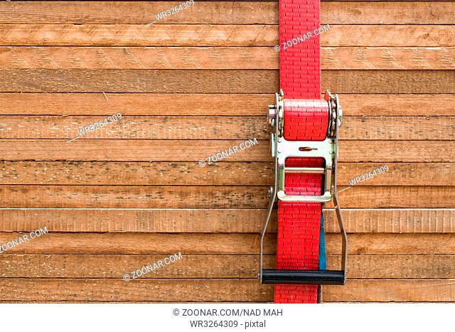 red ratchet strap fixing wood boards / wooden planks / stacked tables