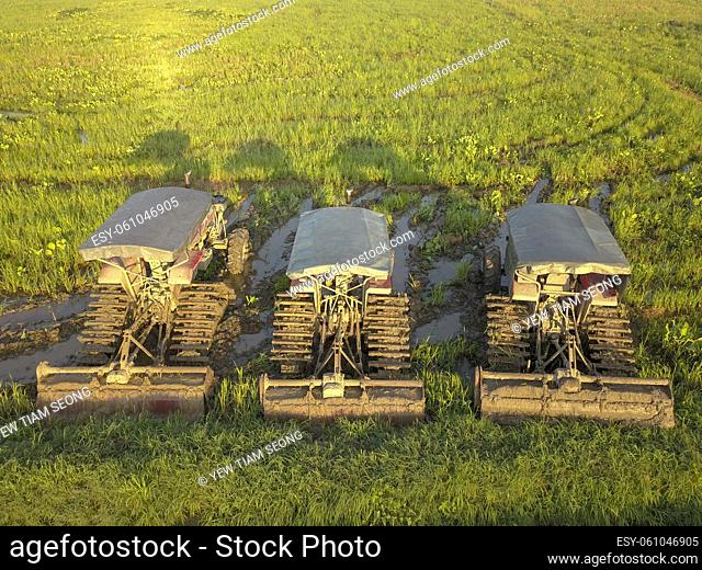 Three tractors park in a row at paddy field. Malaysia main agriculture