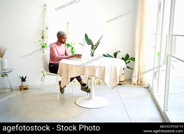 African businesswoman working on laptop in living room