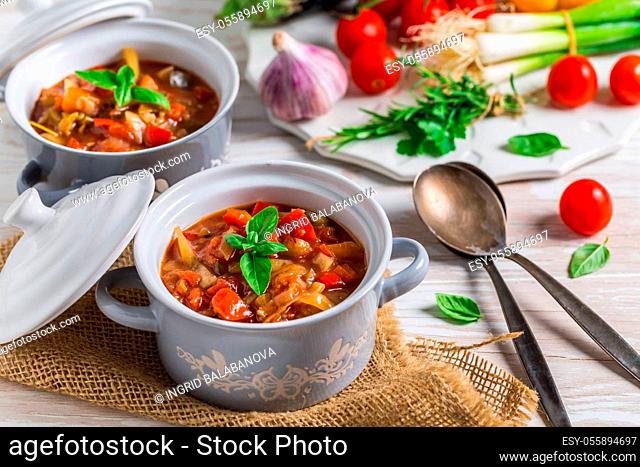 Delicious Italian vegetable minestrone soup served in small pots with ingredients