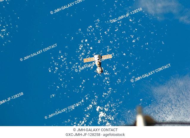 Backdropped against a mixture of blue sky and clouds, the Soyuz TMA-21 spacecraft departs from the International Space Station and heads toward a landing in a...