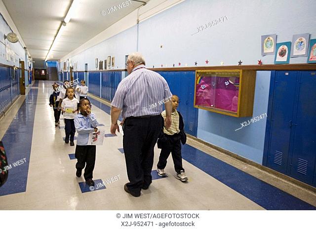 Detroit, Michigan - A kindergarten teacher with his students in the hallway at Guyton Elementary School, part of the Detroit Public School system