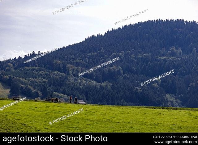 23 September 2022, Baden-Wuerttemberg, Horben: People standing on the hay hump near Horben while the Black Forest can be seen in the background
