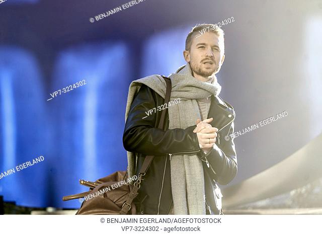 confident young man wearing stylish winter clothes, men's fashion, in Munich, Germany