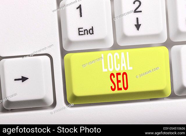 Writing note showing Local Seo. Business concept for helps businesses promote products and services to local customers White pc keyboard with note paper above...