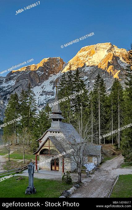 braies, dolomites, bolzano province, south tyrol, italy. the chapel on lake braies with the seekofel in the background