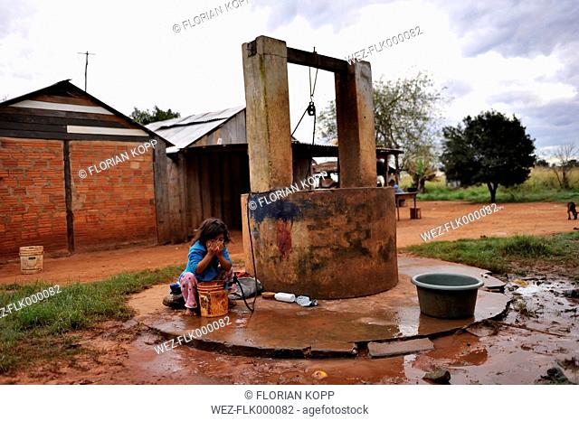 Paraguay, Caaguazu, Jaguary, Guarani girl washing face at well