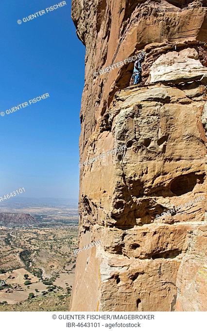 Local guide climbs to the entrance Abuna Yemata monolithic church in the Gheralta Mountains near Hawzien, Tigray, Ethiopia