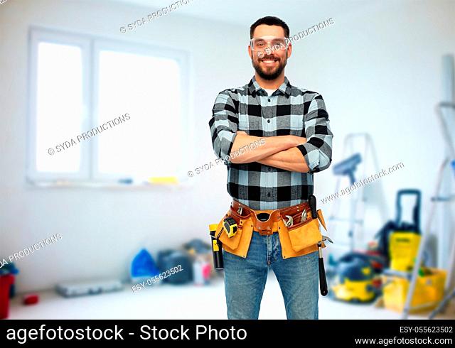 happy male worker or builder with crossed arms