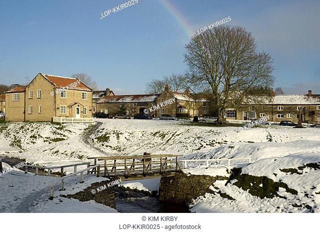 England, North Yorkshire, Hutton le Hole, A rainbow in view over Hutton le Hole village in winter