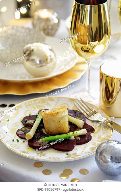 Appetizer with goat cheese in a white bread crust on a bed of vegetables