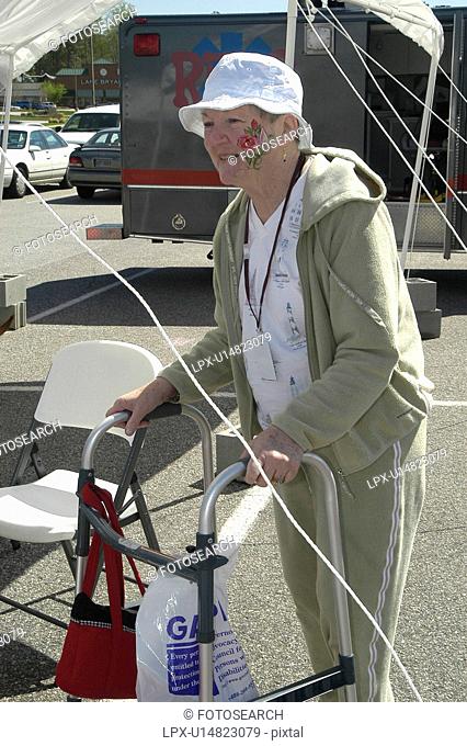 Woman with face paint uses walker at outdoor event