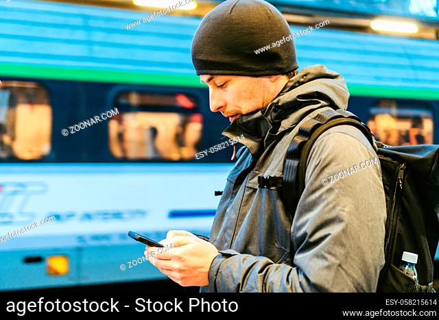 Train Station in Sopot, Poland, Europe. Attractive man waiting at the train station. Thinking about trip, with backpack. Travel photography