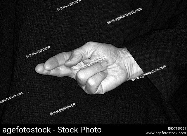 Fingers crossed behind the back, gesture, broken promise, studio photography