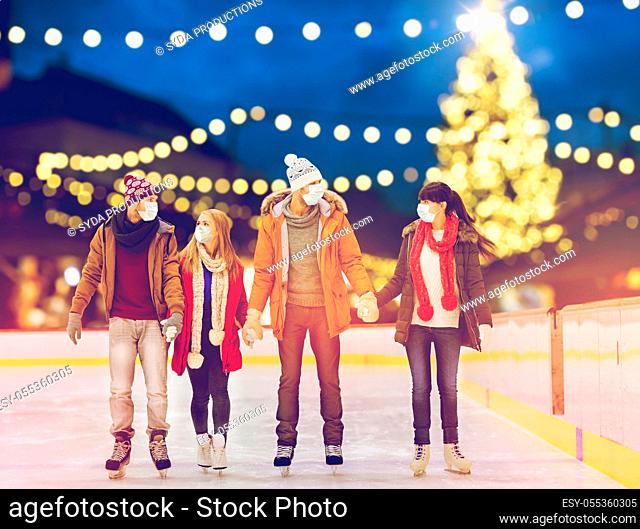 friends in masks on christmas skating rink