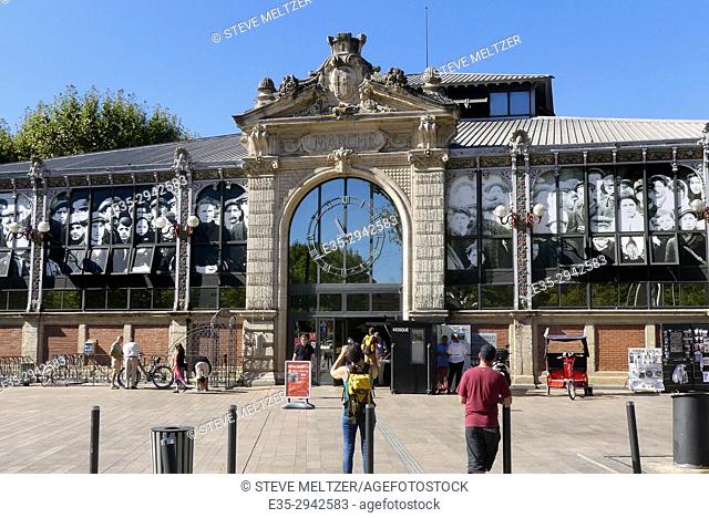 A person takes a photo of ""Les Halles"" market in Narbonne France that built in 1907