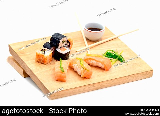 Close Up Of Various Types Of Japanese Fresh Prepared Sushi on wooden table on white isolated background