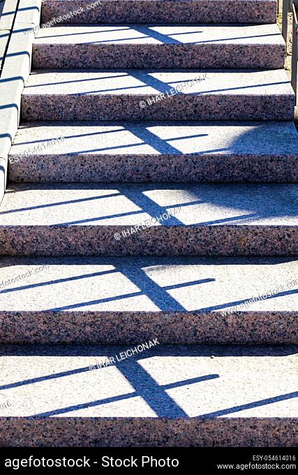 part and close-up of concrete stairs on the street, a real new design with shadows from the railing, Sunny day