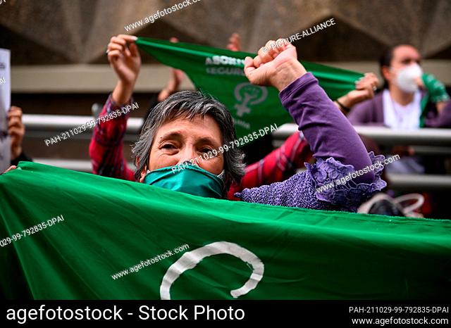 29 October 2021, Bolivia, La Paz: Women wearing green mouth-to-nose coverings wave green scarves during a rally outside the bishops' conference as part of...
