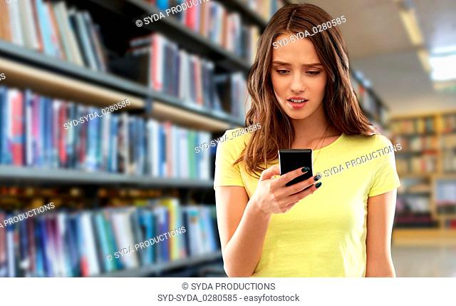 young woman or teenage girl using smartphone