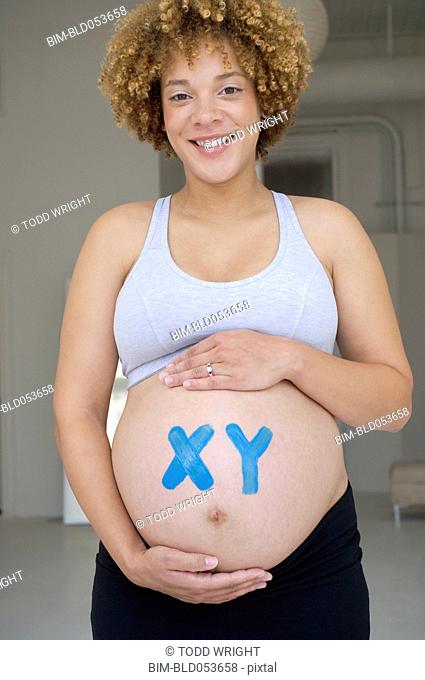 Pregnant African woman with XY painted on belly