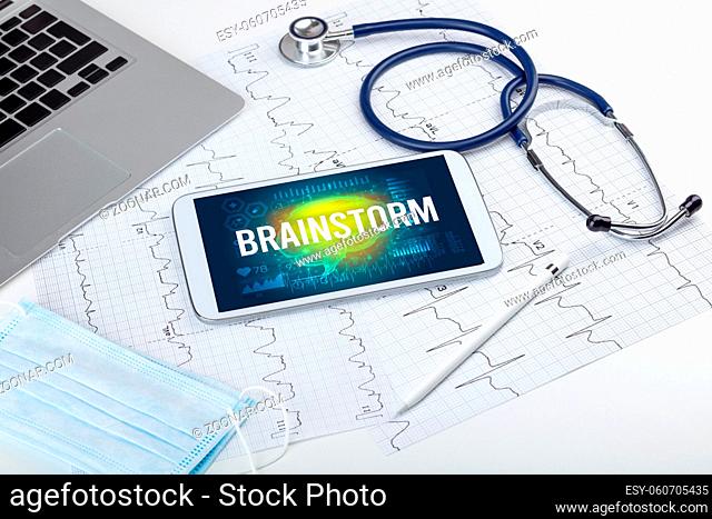 Tablet pc and medical tools with BRAINSTORM inscription, social distancing concept