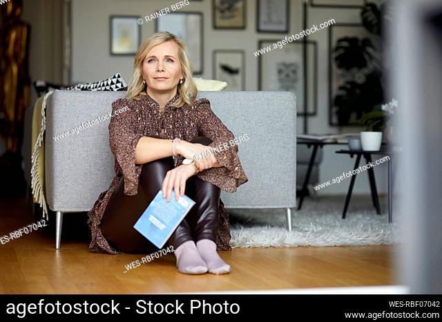 Blond woman relaxing at home sitting on the floor