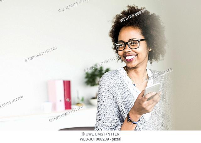 Portrait of smiling businesswoman wearing glasses in office