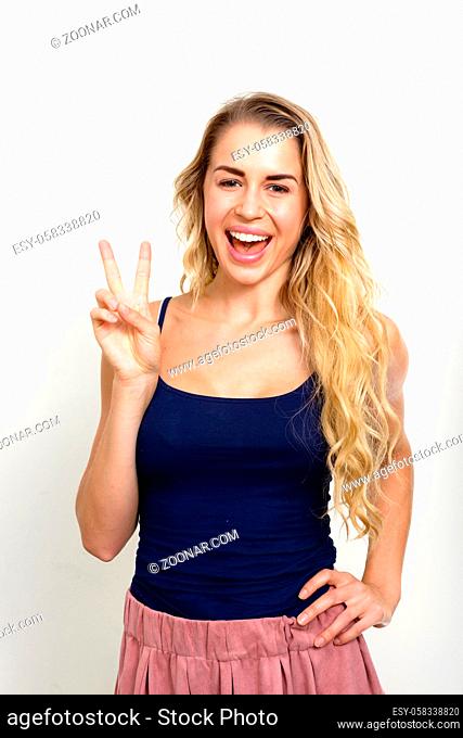 Studio shot of young beautiful woman with blonde wavy hair against white background
