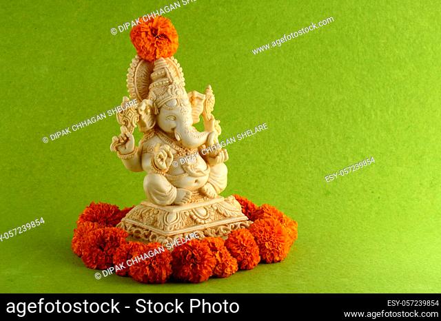 Hindu God Ganesha. Ganesha Idol on green background