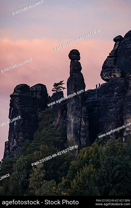 03 October 2023, Saxony, Pfaffendorf: Rocks of the Pfaffenstein in Saxon Switzerland with the Barbarine, a free-standing rock needle