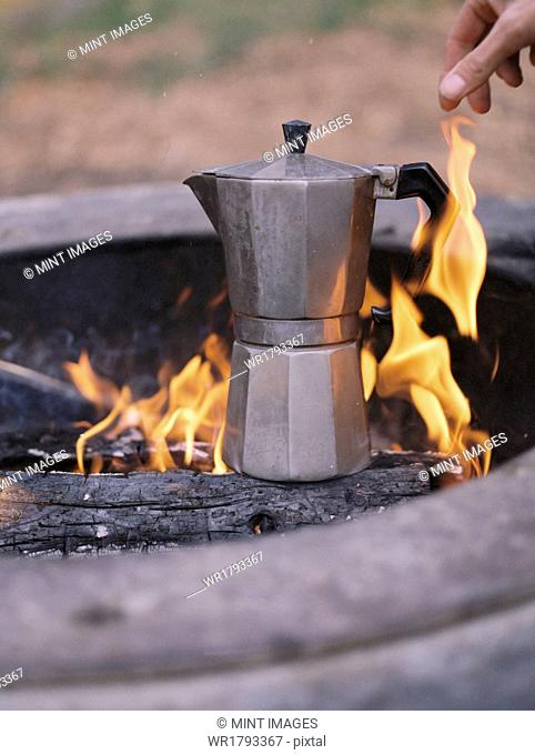 Espresso maker standing over an outdoor fire