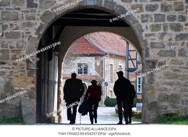 02 April 2019, Saxony-Anhalt, Blankenburg: Visitors enter the Michaelstein Monastery through an archway. The monastery Michselstein is one attraction richer