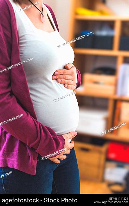 Close up of pregnant tummy, Caucasian mother with white shirt and magenta jacket